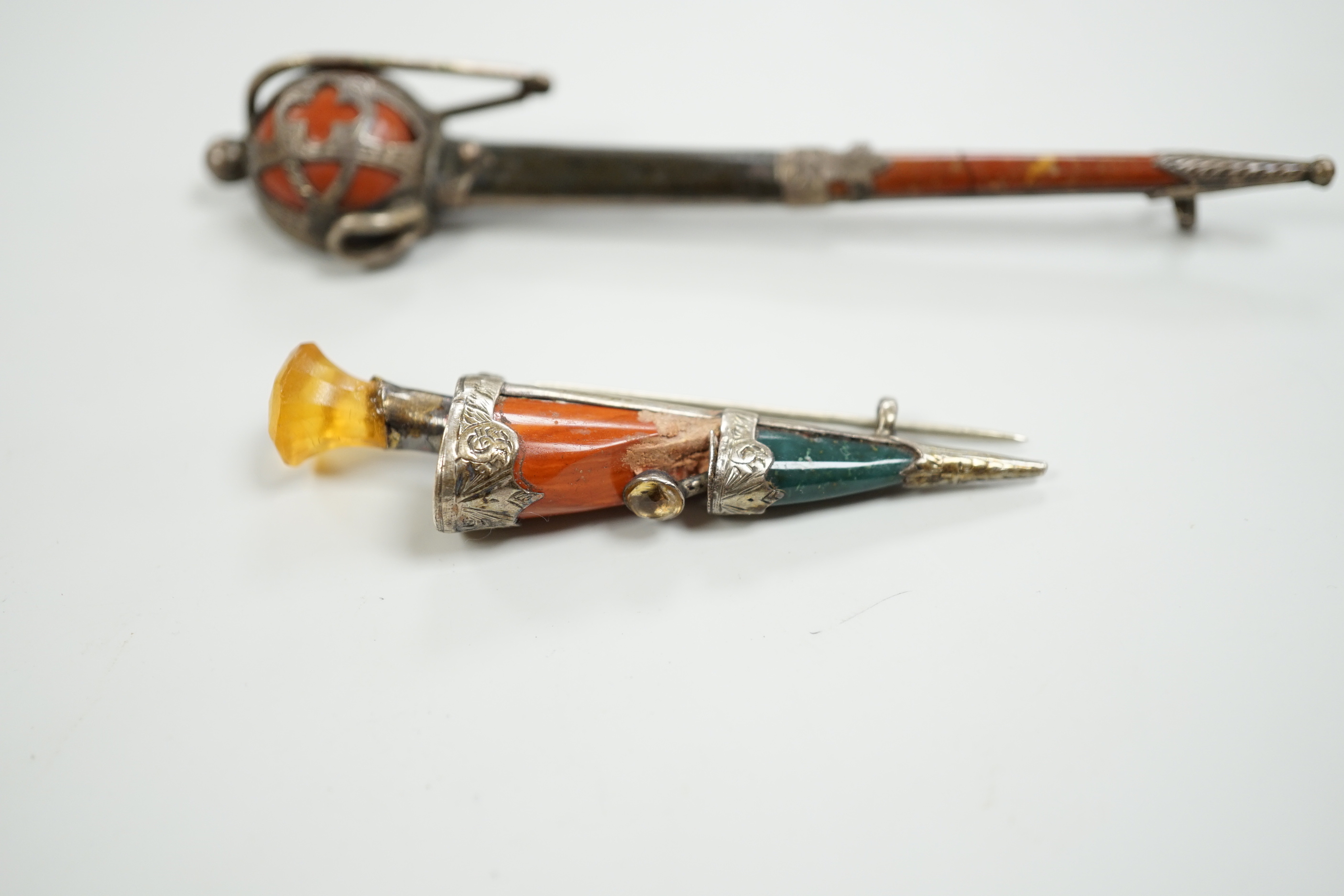 Two early 20th century white metal and Scottish hardstones set dagger or sword brooches, largest 11.6cm.